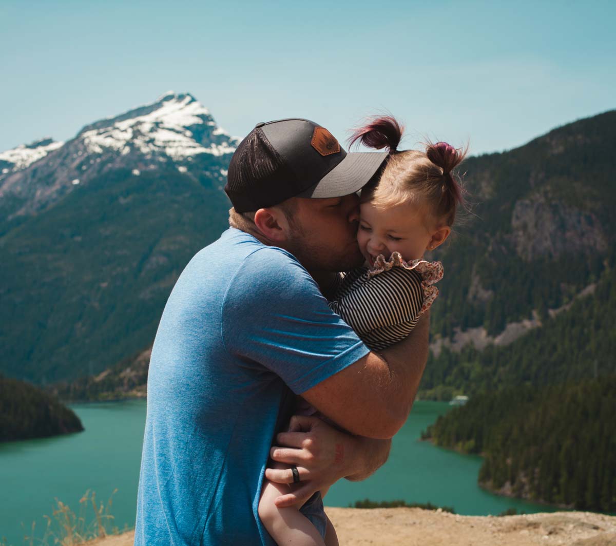 Father and daughter in front of mountain landscape