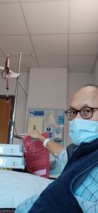 Simon Chin in hospital during with a face mask on