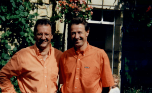 Chris and Stewart both with orange shirts on, smiling at the camera