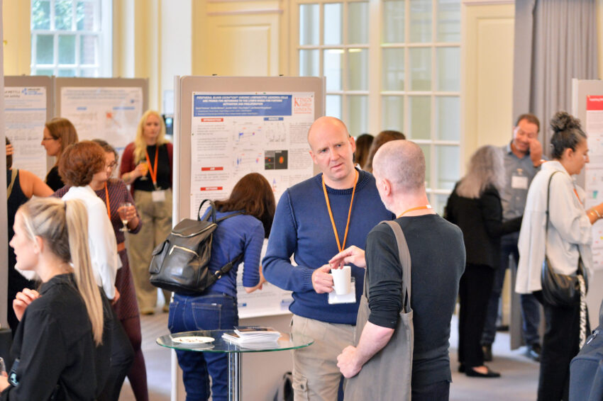 Attendees of the 2023 Annual Science Seminar looking around the event and talking