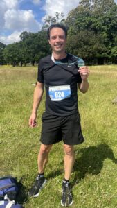 Braithe holding up a runners medal outdoors