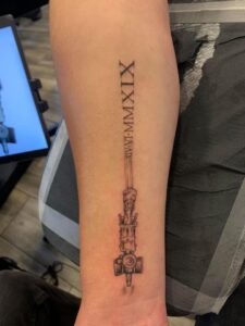 Martin Anderton tattoo of a canula on his arm with his transplant date in roman numerals