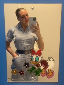 Molly taking a picture in a mirror in uniform