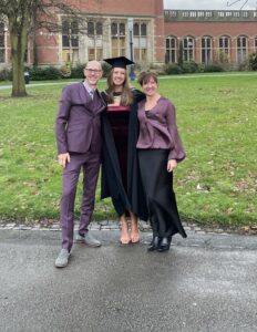 Dad, Molly and Mum at Molly's graduation outside a university building
