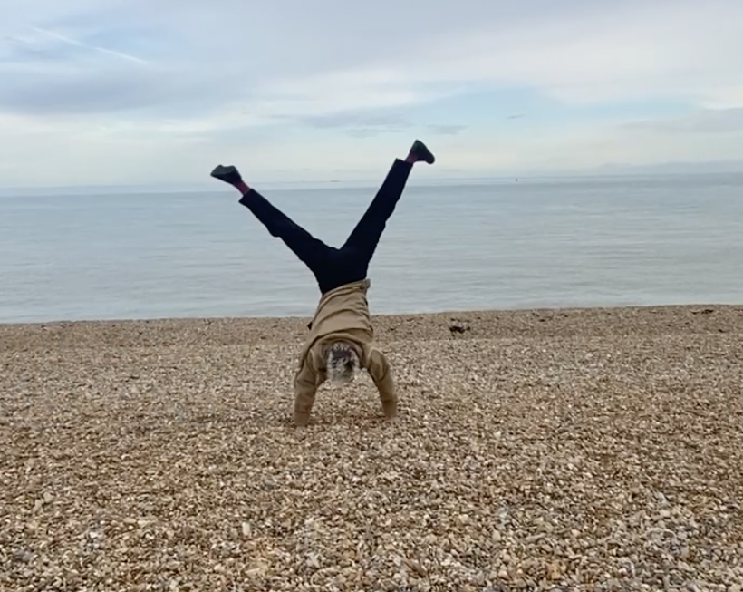 Lucy cartwheeling on a beach