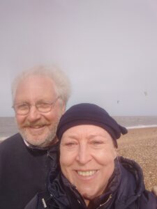 Claire outside on the beach with her husband after treatment